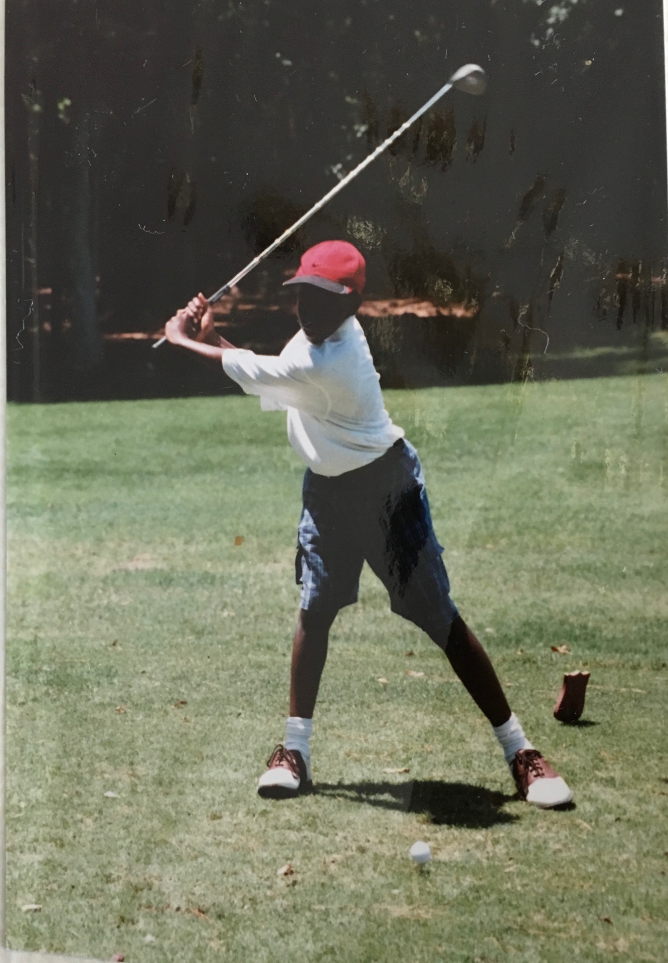 Young Olajuwon Ajanaku mid-swing on the golf course